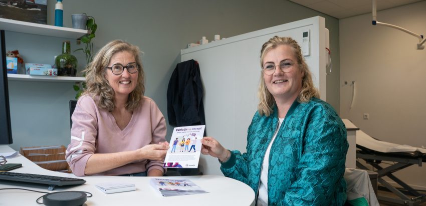 Huisarts Merijn en welzijnscoach Femke houden de informatiefolder van Welzijn op Recept omhoog